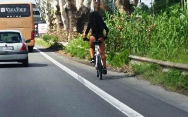 donna che va sulla salsria con la bicicletta